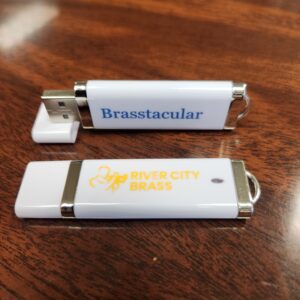 White thumb drive with blue "Brasstacular" text and gold River City Brass logo