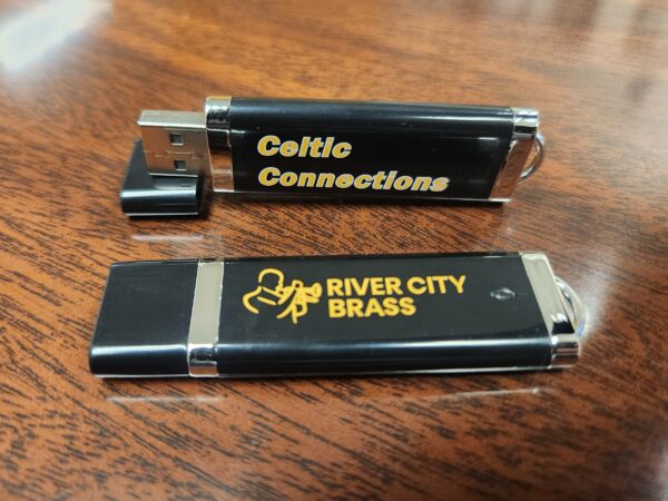 Black thumb drive with yellow "Celtic Connections" text and yellow River City Brass logo